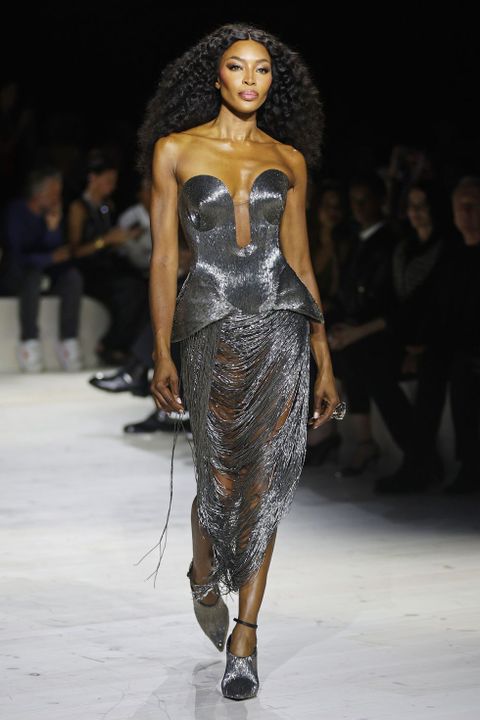 Naomi Campbell in a sparkling dark dress on the catwalk.