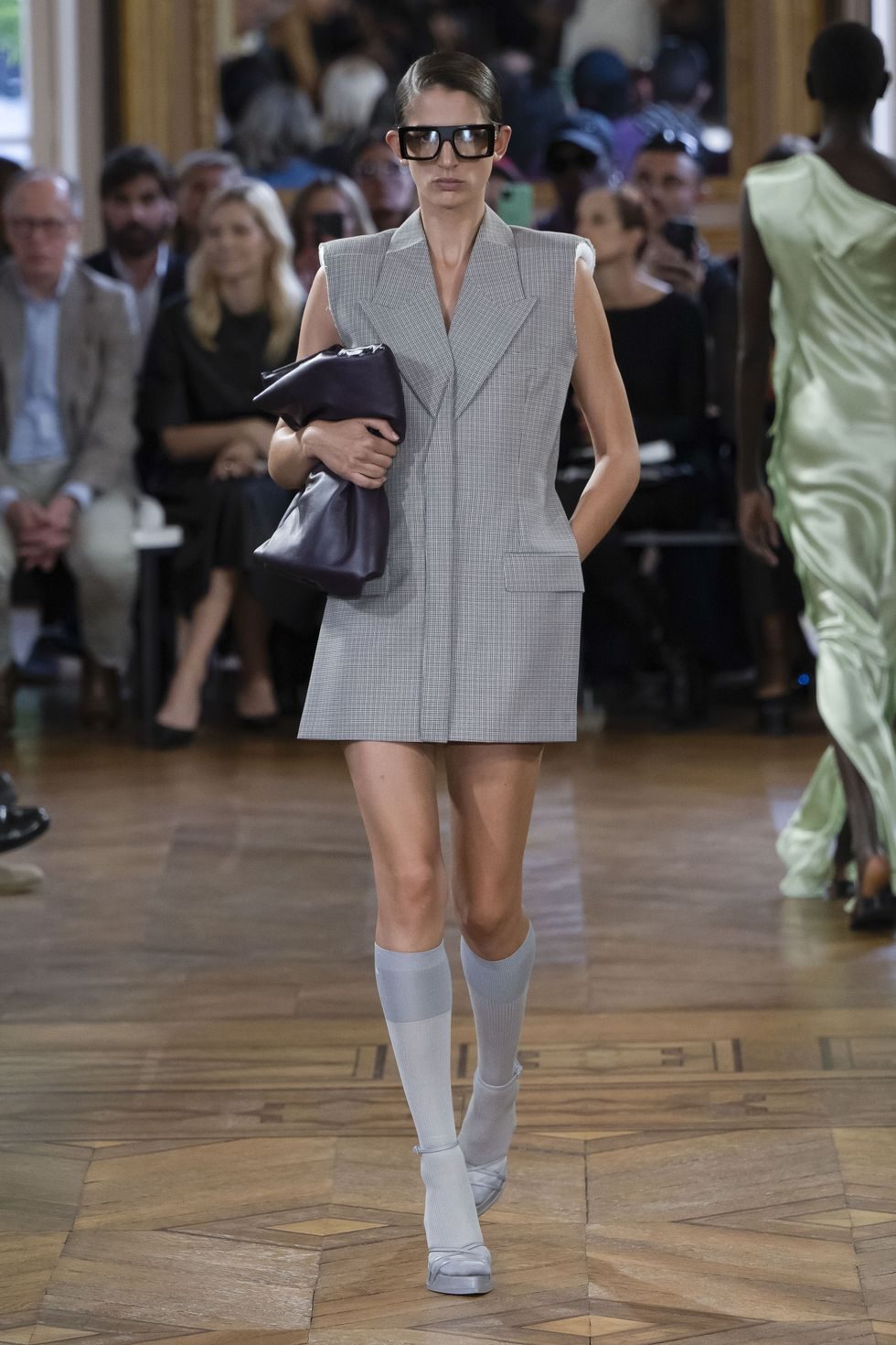 Model in a gray dress on the catwalk.