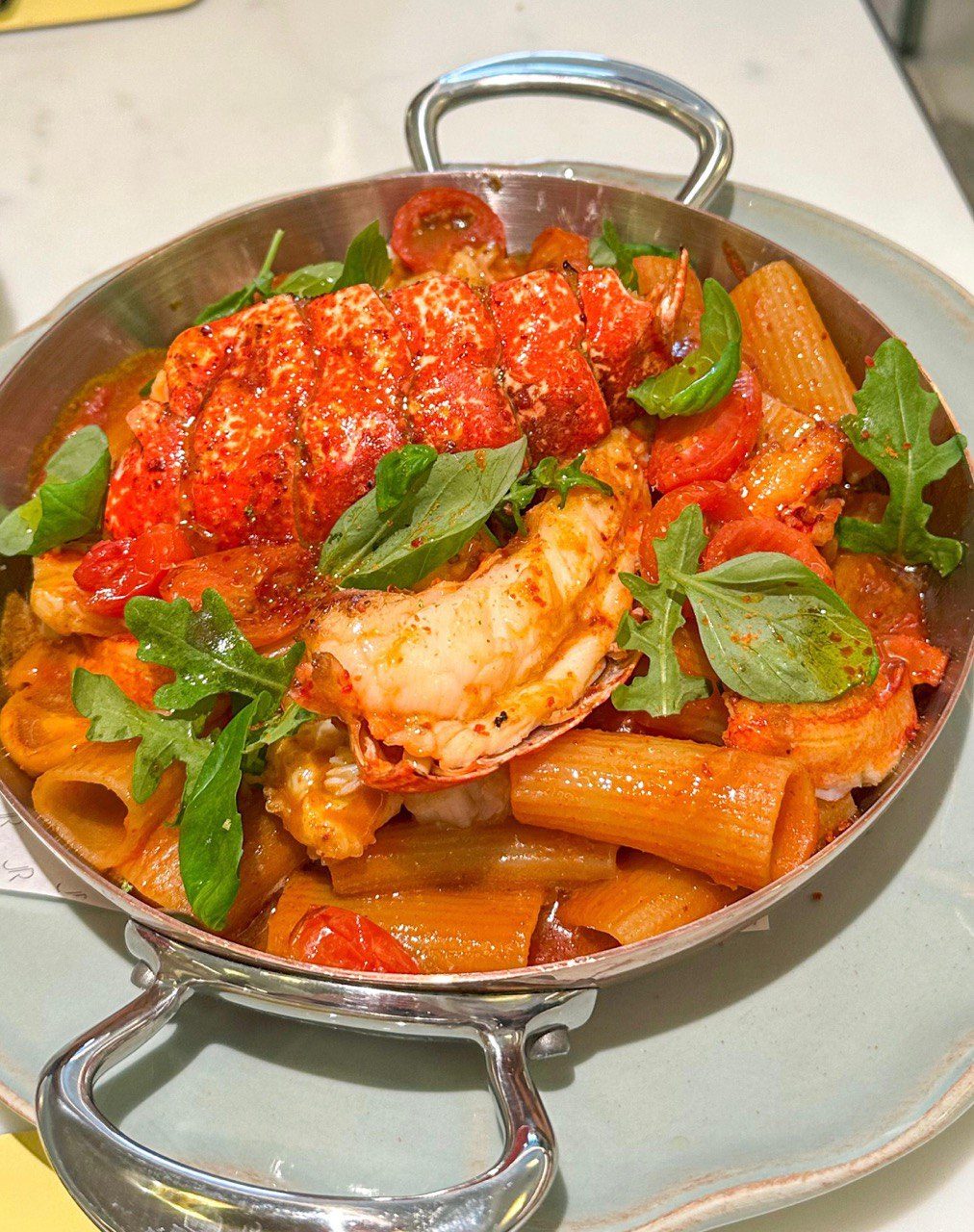 Main course Rigatoni with lobster in a vibrant tomato sauce.