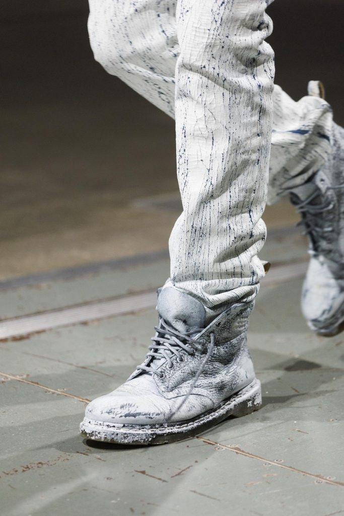 Close-up of square-toed boots paired with loose, flowing trousers.