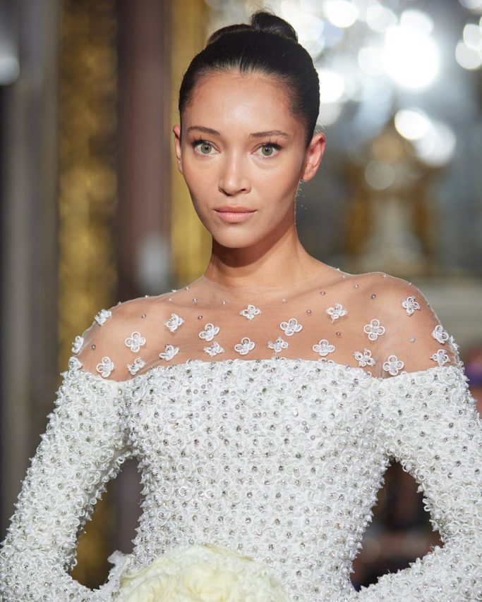 A soft pink embroidered tulle gown with flowing drapery, perfect for red carpet glamour.